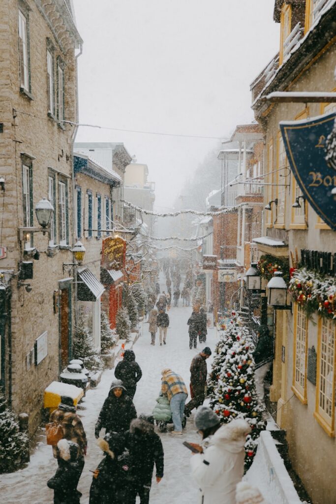 People walking on a snowy street in a historic town.